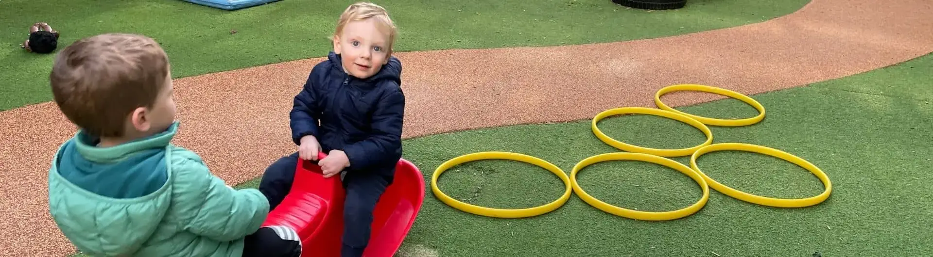 happy little boy on red see-saw